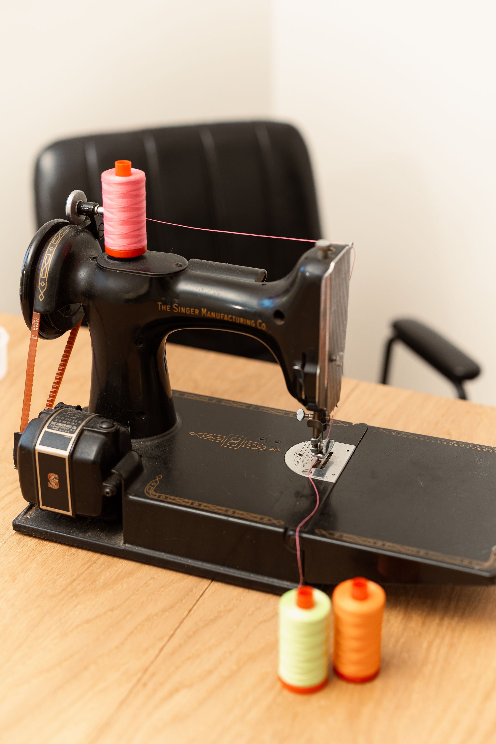 black vintage Singer featherweight sewing machine with  modern neon thread spools
