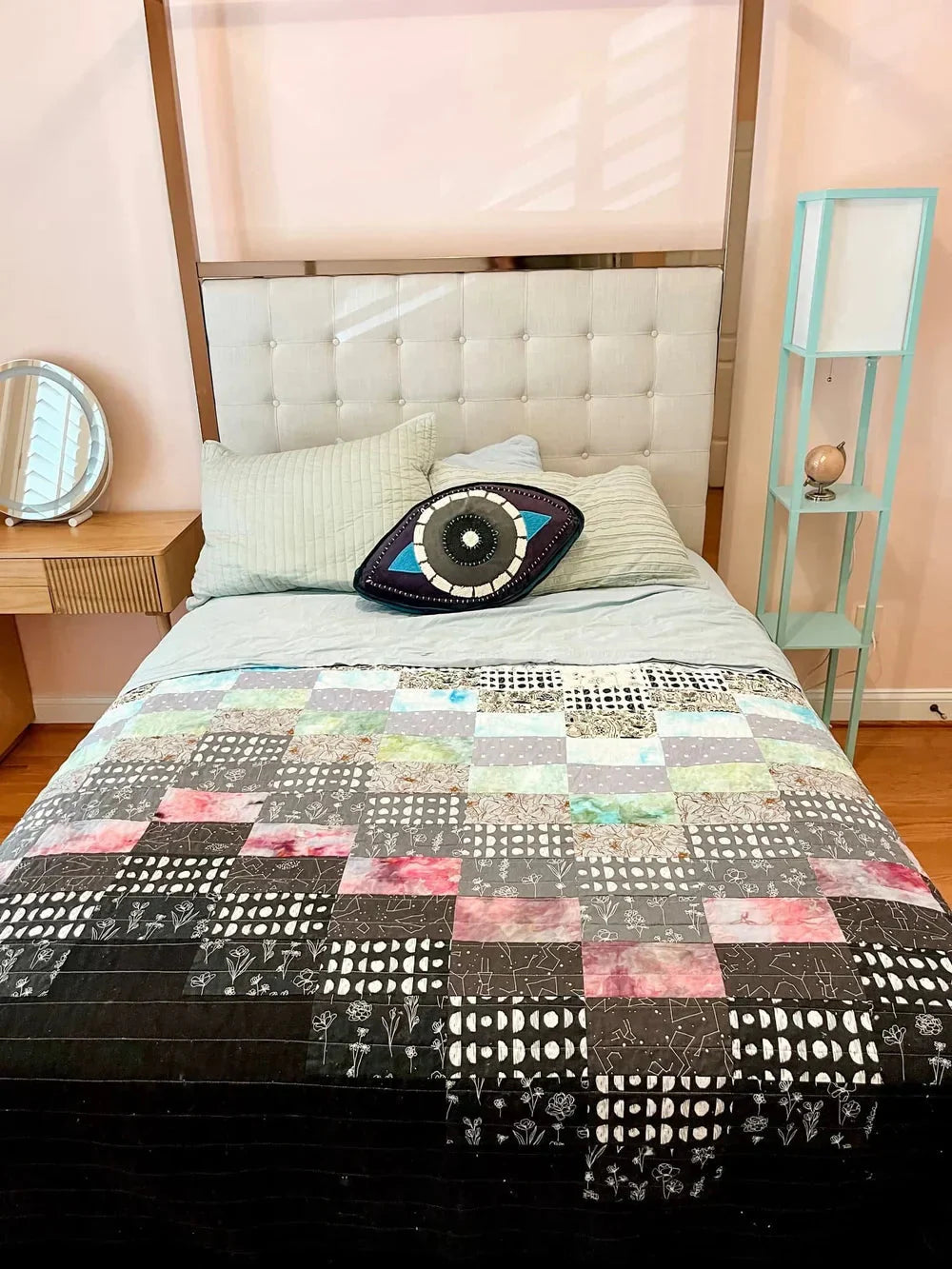 gradient quilt with hand dyed fabrics in black and white shades with a weird eye pillow on a canopy bed