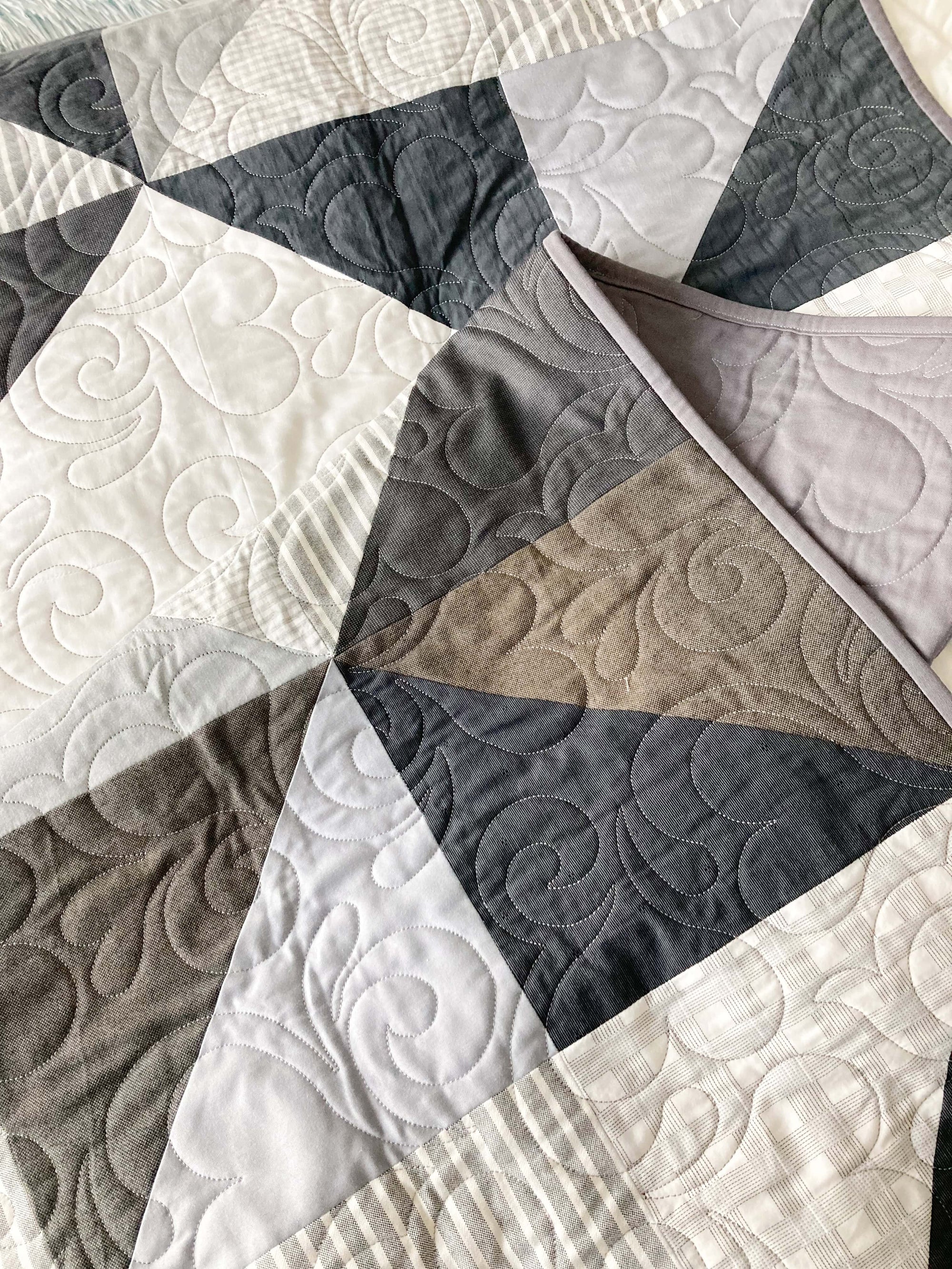 an artfully folded modern quilt made from neutral toned clothing