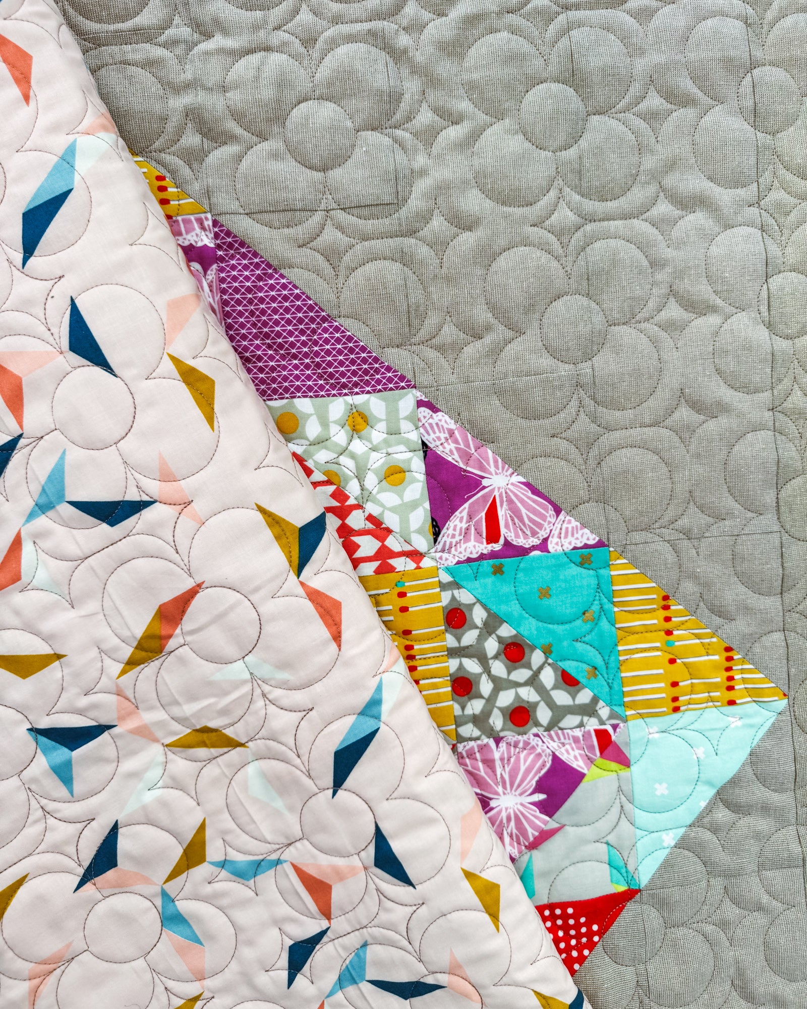 Colorful quilt with geometric patterns on a linen background