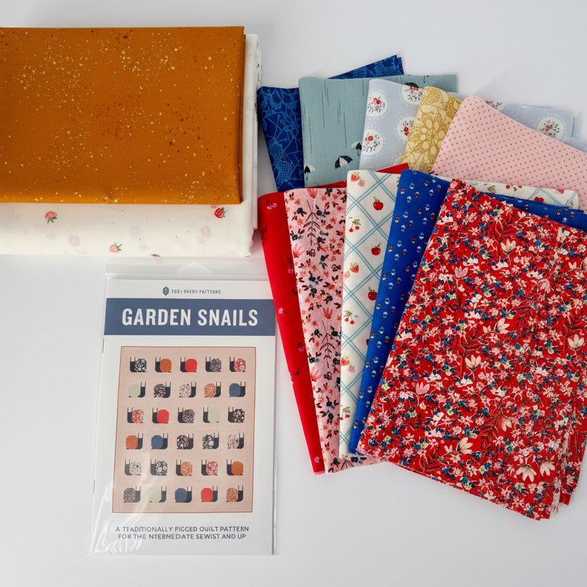 Collection of patterned fabric squares and a pattern book titled 'Garden Snails' on a white background.